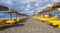 Rows of bright yellow sunbeds lay empty under grey clouds, Torrox Costa, Spain.