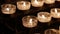 Rows of burning lit candles / tealights in Catholic Christian Church