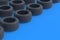 Rows of car tyres on blue background. Automotive parts