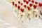 Rows of champagne glasses decorated with strawberries at the buffet table. Close-up