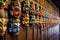 rows of colorful balinese masks hanging on a wall