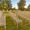 Rows and columns of chairs on a sunlit yard