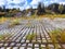 Rows of concrete cubes or rectangles on the bank of a river with grass. Breakwaters, protection from water in nature