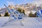 Rows of deckchairs for sunbathing on snow in Dolomites, Italy, with Sella group as a backdrop at sunset