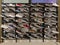 Rows of different sneakers of different brands are displayed on the shelves of a shoe store