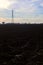 Rows of electricity pylons and power lines over cultivated fields on a winter day in the italian countryside