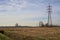 Rows of electricity pylons and power lines over cultivated fields on a winter day in the italian countryside