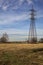 Rows of electricity pylons and power lines over cultivated fields on a winter day in the italian countryside