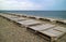 Rows of empty deckchairs on the empty pebble beach