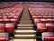 Rows of empty orange stadium seats going upward