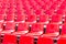 Rows empty red plastic seats in a stadium