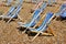 Rows of empty traditional deckchairs on beach