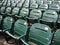 Rows of empty wet green stadium seats