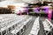 Rows of empty white chairs for a conference in a large auditorium hall