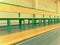 Rows of empty wooden benches in school sporting hall. Tribune in gym for fans