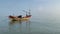 Rows of fishing boats leaning on a sandy beach with blue skies