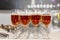 Rows of glasses with pink champagne on a festive buffet table. Exit registration of events. Close-up