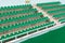 Rows of green spectator seats at sport facility with nobody, diagonal view.