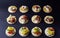 Rows of hors d`oeuvres crackers topped with variety of meats cheese spreads