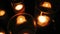 Rows of hundreds burning votive candles in dark moody sacral environment, background texture