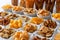 Rows of many types of savory snacks in white ceramic dishes.