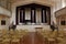 Rows of metal seats arranged to face podium in meeting room, Oneida Community Mansion House, New York, 2018