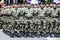 Rows of military troop marching on streets during sunny summer day