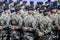 Rows of military troop marching on streets during sunny summer day