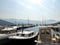 Rows of motorized pleasure and fishing boats on the pier near the city of Budva Montenegro. The background has mountains and blue