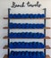 Rows of neatly organized blue beach towels on wooden shelves