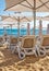 Rows of plastic reclining chairs / lounge recliners / sunbeds on a golden sandy beach