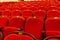 Rows of red auditorium chairs for print