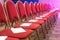 Rows of red chairs in conference hall, empty meeting or event room.