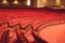 Rows of red cinema seats. View of empty theater hall. Comfort chairs in the modern theater interior