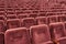 Rows of red cinema seats. View of empty theater hall. Comfort chairs in the modern theater interior