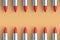 Rows of red lipsticks on beige background. Cosmetic accessories. Make-up tools. Top view. Copy space