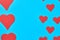 Rows of red paper hearts on blue background. Concept of Valentines Day