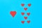 Rows of red paper hearts on blue background. Concept of Valentines Day. Top view