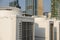 Rows of rooftop HVACs on the roof deck of an office tower with taller towers in the background. VRF or VRV air conditioner.