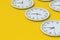 Rows of round minimalist wall clocks on yellow background. Time management