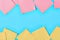 Rows of scattered yellow and pink square blank paper stickers on blue background. Copy space