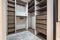 Rows of shelves and clothes hangers in the wardrobe. empty big wardrobe room in modern apartment or hotel