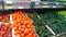 Rows of shelves with red tomatoes and green cucumbers in local farmers market or supermarket. Fresh vegetables. Rich harvest. Supp