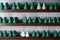 Rows of shoe lasts for shoemaking. Pairs of plastic green and white lasts on shelves. Shoemaker tools in workshop
