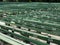 Rows of simple green seats near empty outdoors scene