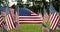 Rows of slow waving American flags, and one single USA flag blowing in the wind. Patriotic concept for US holidays, 4th of July,