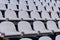 Rows of stadium grandstand seat. Rusty plastic white stadium seat.