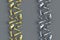 Rows of strewn metallic golden and silver chess figures on gray background