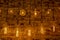 Rows of transparent incandescent lamps of various shapes with luminous threads on background of brown brick wall.