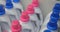 Rows unbranded white container bottles of household chemicals pink and blue caps